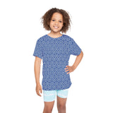 Child wearing a blue geometric patterned shirt and light blue shorts on a white background