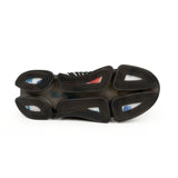 Close-up of a shoe sole with black rubber and multicolored accents on a white background