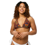 Woman wearing a colorful patterned bikini top on a white background