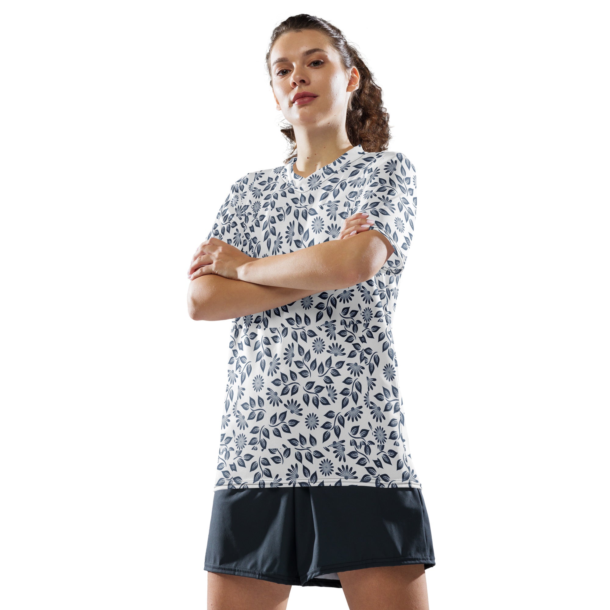 Woman wearing a white t-shirt with a blue floral pattern and black shorts on a white background