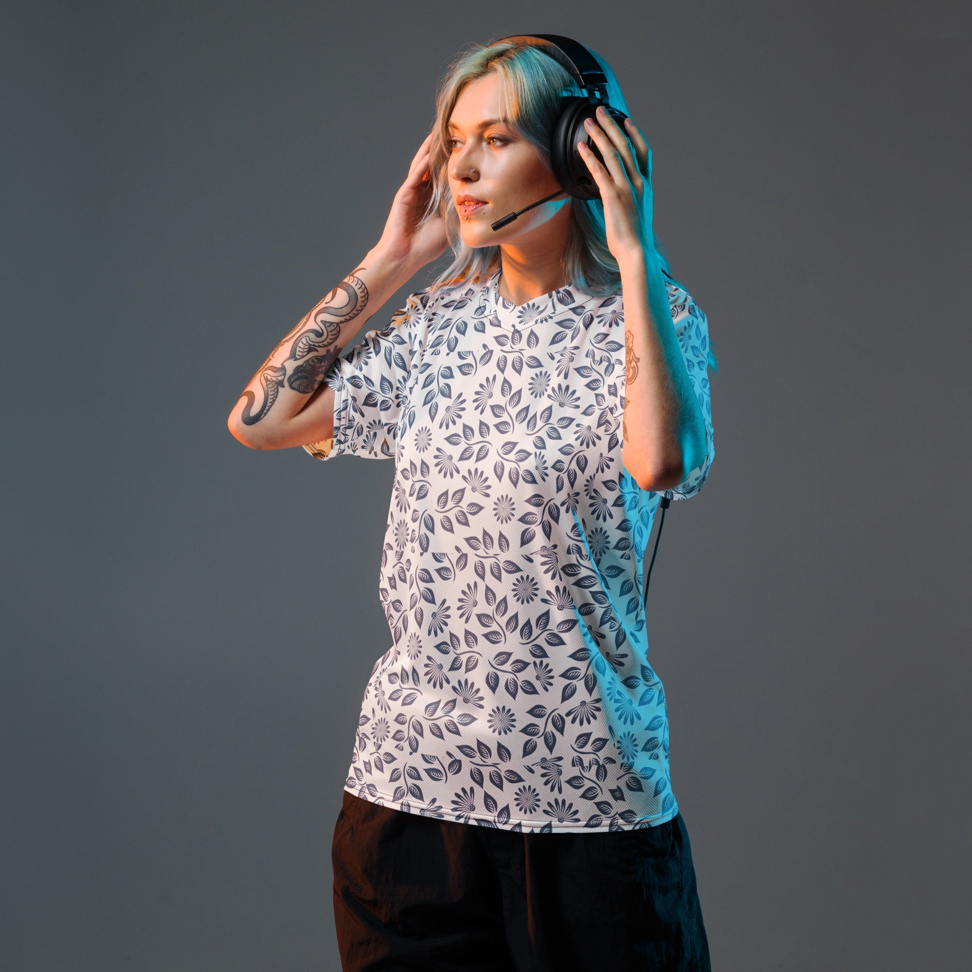 Person wearing headphones and a patterned shirt on a gray background