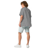 Person wearing a black and white geometric patterned shirt with light blue shorts on a white background
