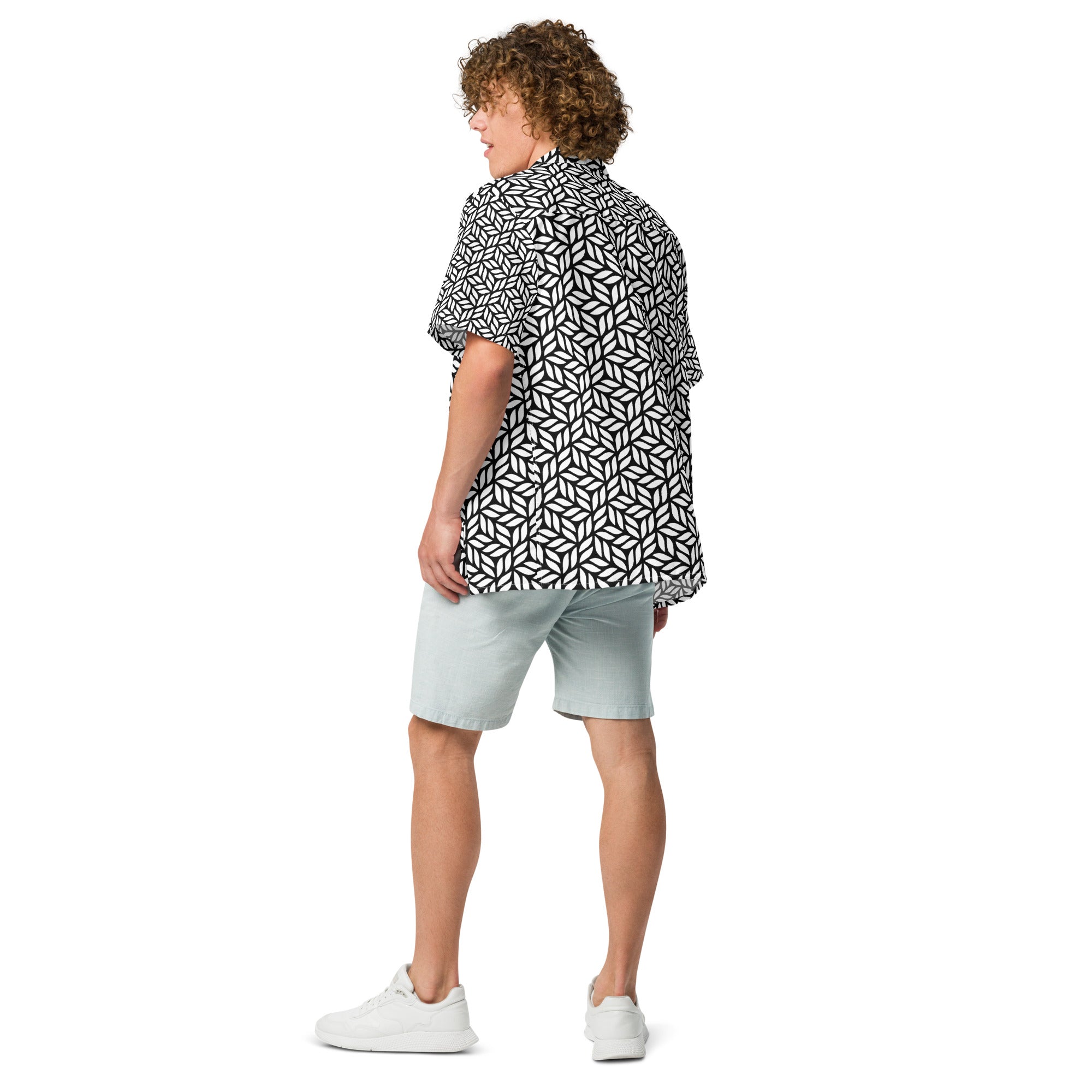 Person wearing a black and white geometric patterned shirt with light blue shorts on a white background