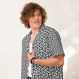 Person wearing a black and white patterned shirt against a plain background