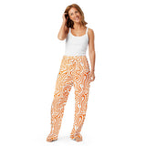 Woman wearing a white tank top and orange patterned pants on a white background