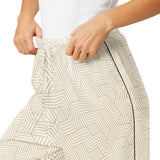 Person wearing a white skirt with geometric pattern on a white background