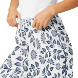 Person wearing a white skirt with blue floral pattern