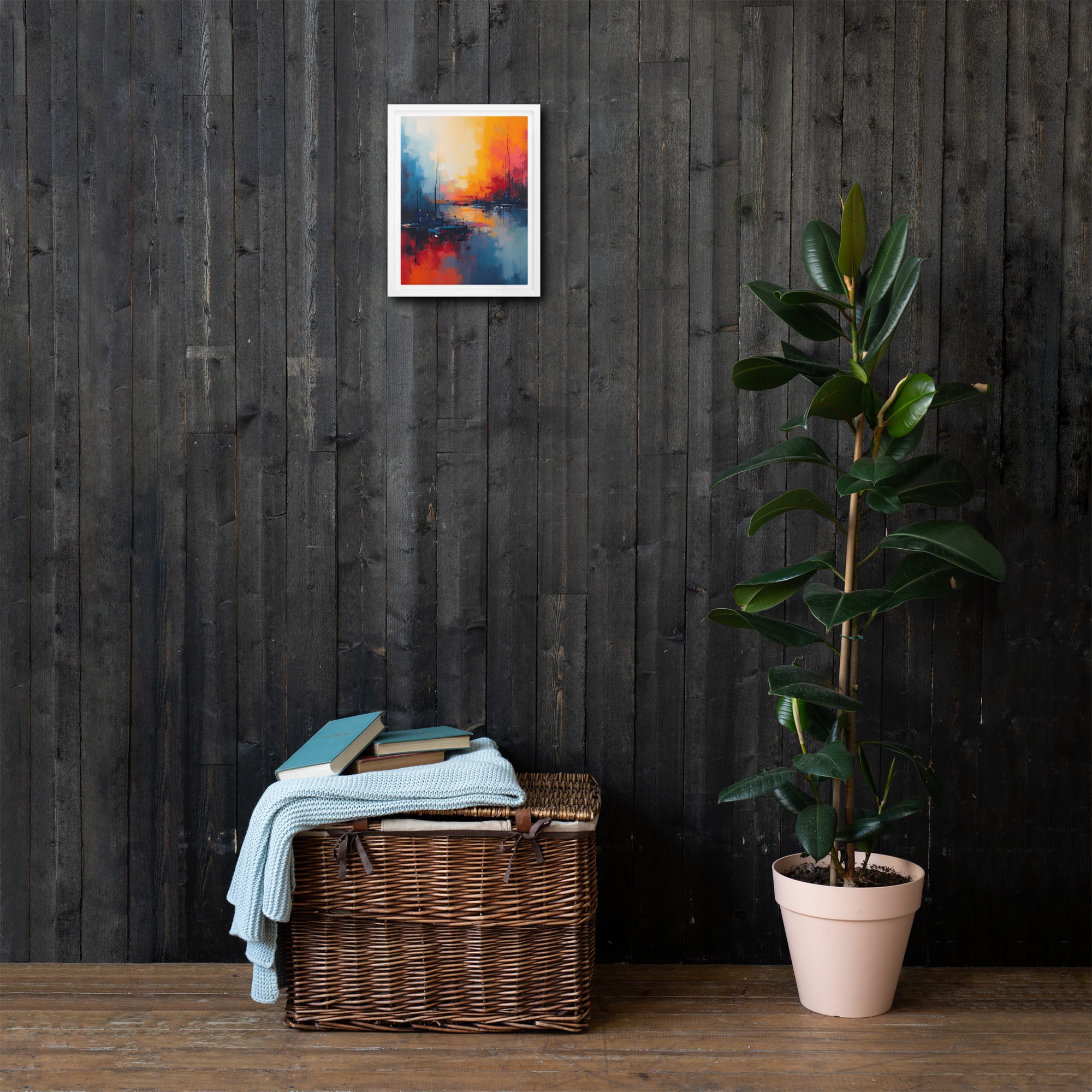 Wicker basket with towels and books against a dark wooden wall with a colorful abstract painting, next to a potted plant.