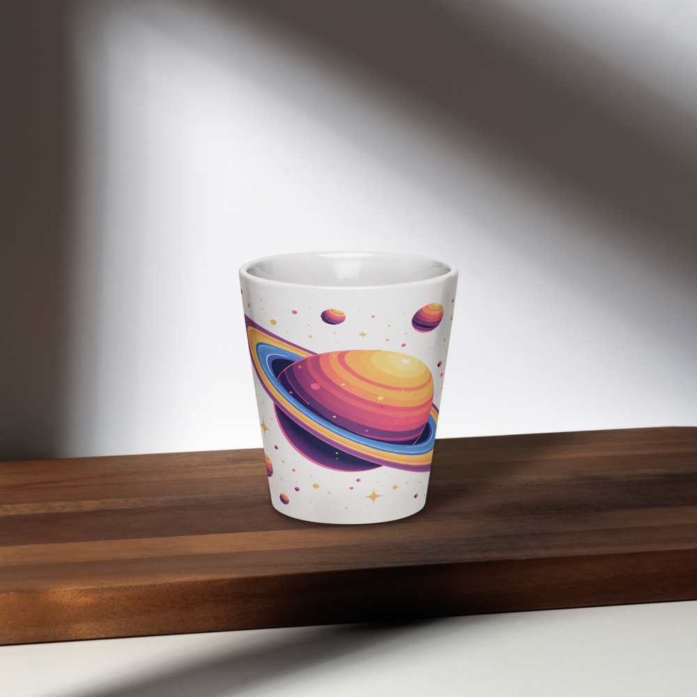 White ceramic tumbler with colorful space-themed design on a wooden surface
