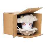 Cardboard box with a colorful mug inside, surrounded by packing peanuts on a white background