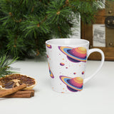 White mug with colorful planet design on a white surface with Christmas decorations.