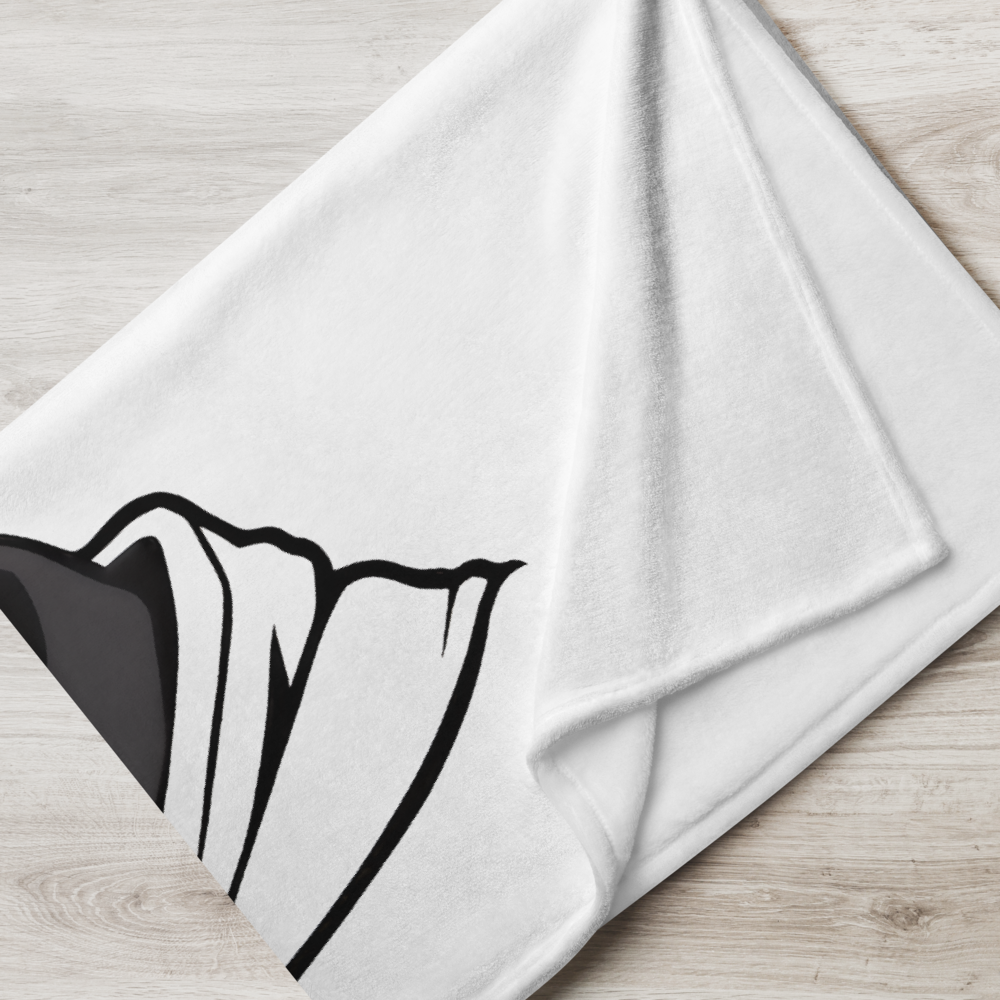 White towel with black geometric design on a wooden surface