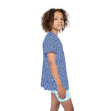 Child wearing a blue geometric patterned shirt and light blue shorts on a white background