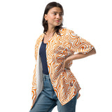 Woman wearing a patterned orange and white shirt with blue jeans on a white background