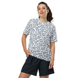 Woman wearing a white blouse with blue floral pattern and black shorts on a white background