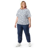 Woman wearing a patterned top and navy pants on a white background