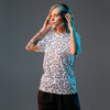 Person wearing headphones and a patterned shirt on a gray background