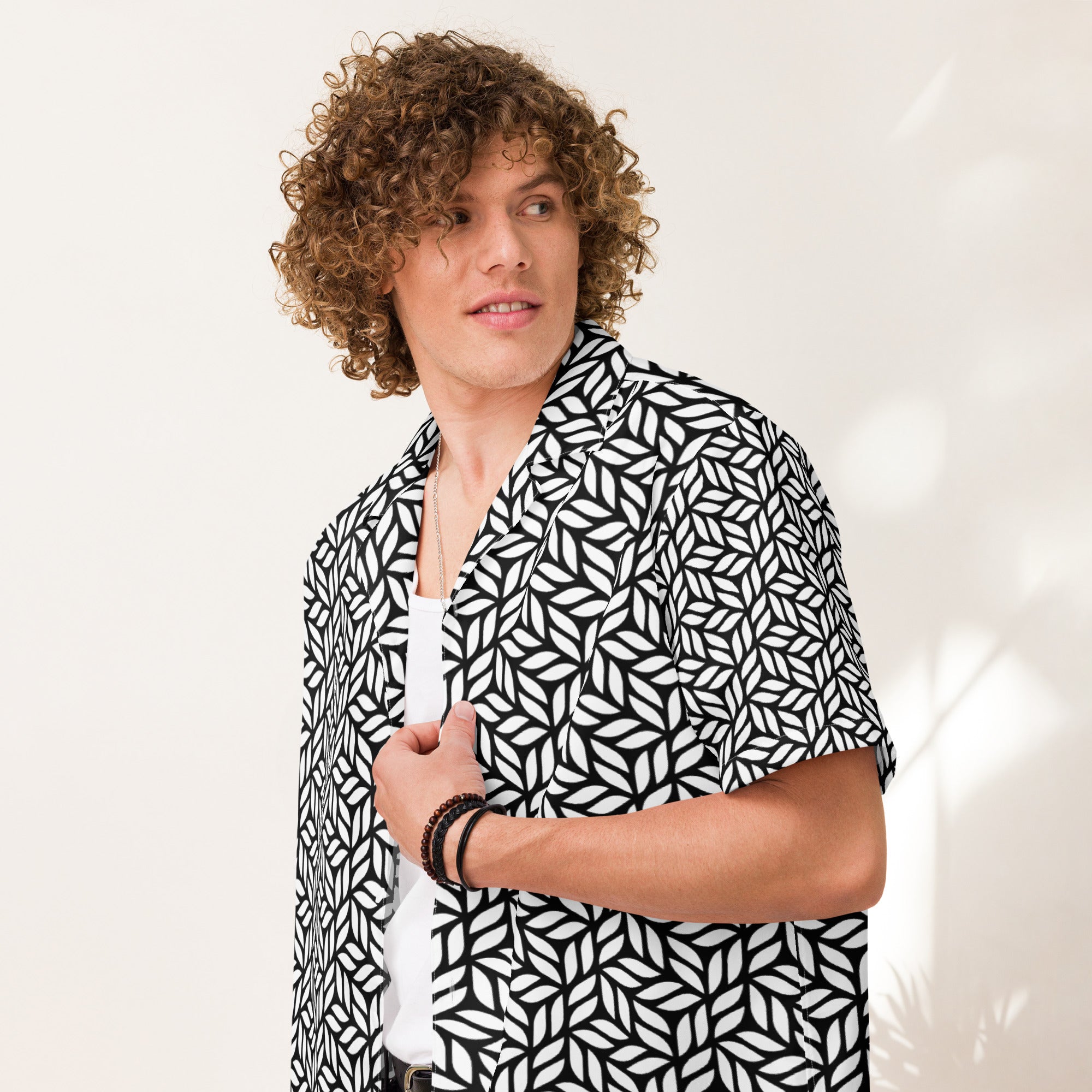 Person wearing a black and white patterned shirt against a plain background