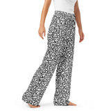 Person wearing black and white patterned pants on a white background
