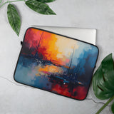 Laptop sleeve with abstract art design on a light gray surface with green leaves.