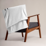 Wooden chair with a gray blanket draped over it against a beige background