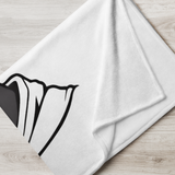 White towel with black abstract design on a wooden surface